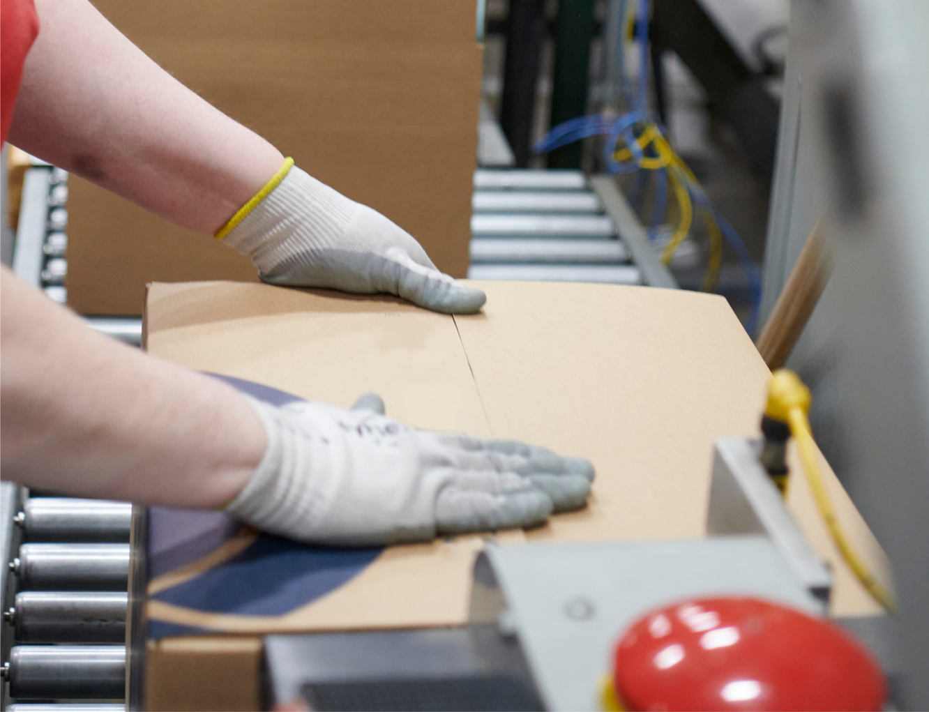 Person packing boxes on a manufacturing line